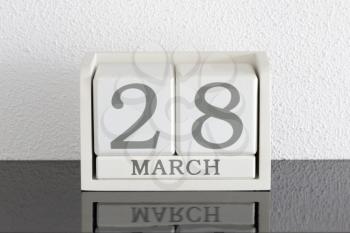 White block calendar present date 28 and month March on white wall background