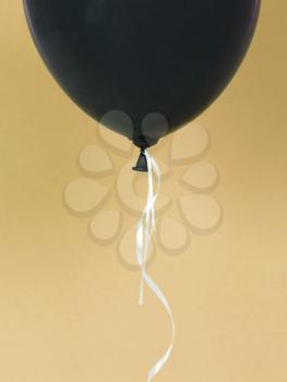 Black balloon isolated on a yellow background
