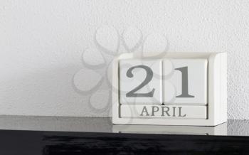 White block calendar present date 21 and month April on white wall background