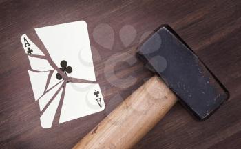 Hammer with a broken card, vintage look, ace of clubs