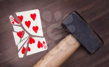 Hammer with a broken card, vintage look, eight of hearts