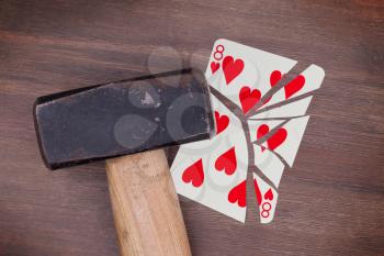 Hammer with a broken card, vintage look, eight of hearts