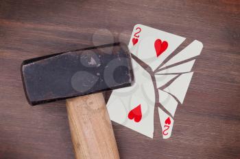 Hammer with a broken card, vintage look, two of hearts