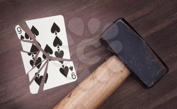 Hammer with a broken card, vintage look, nine of spades