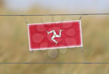 Border fence - Old plastic sign with a flag - Isle of Man