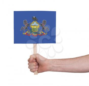 Hand holding small card, isolated on white - Flag of Pennsylvania