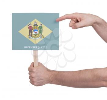 Hand holding small card, isolated on white - Flag of Delaware