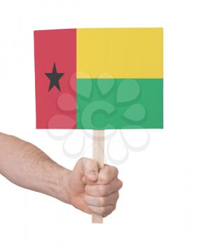 Hand holding small card, isolated on white - Flag of Guinea Bissau
