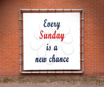 Large banner with inspirational quote on a brick wall - Every sunday is a new chance
