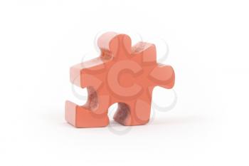 Closeup of big orange jigsaw puzzle piece isolated on white