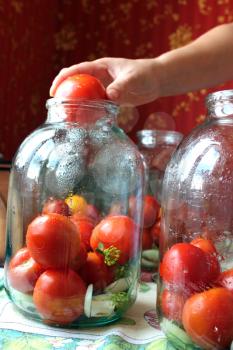 many tomatos in jars prepared for preservation