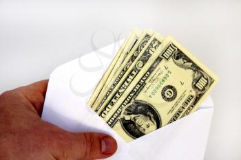 hand holding dollar banknotes in envelope as a bribe isolated on a white background