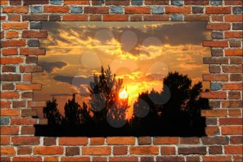 broken brick wall and view to the beautiful sunset with silhouettes of trees