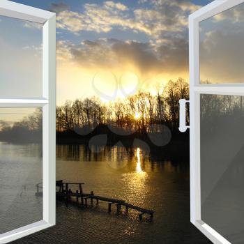 white window opened to the beautiful sunset with river