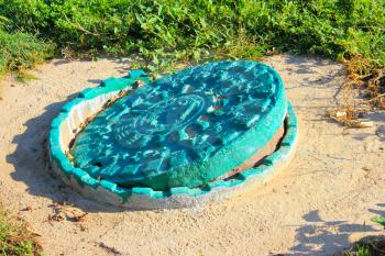 Old vintage sewer hatch painted with green paint