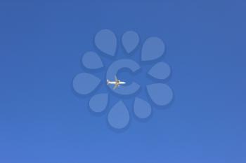White airplane flying on blue sky background