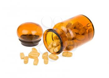 Pills spilling out of a vintage apothecary bottle isolated on white