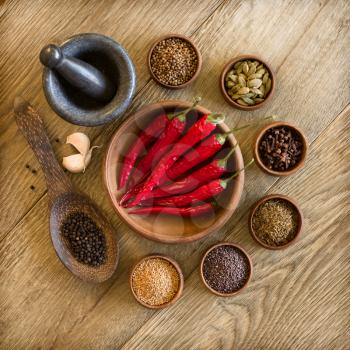 Spices in wooden bowls and mortar with pestle. Cooking ingridients, gourmet kitchen, eastern spices concept.