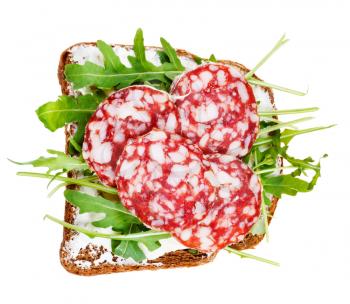 sandwich from rye bread, soft cheese, salami and fresh arugula isolated on white background