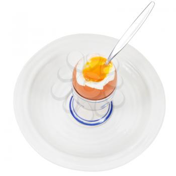 soft boiled egg in egg cup with spoon on white plate isolated on white