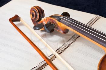 violin bow and scroll on music book close up