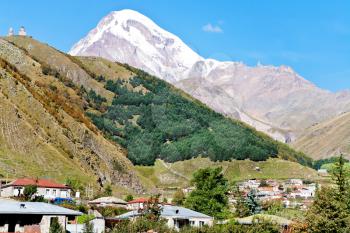 view of village Kazbegi, Gergeti Trinity Church and Mount Kazbek in Caucasus Mountains in Georgia