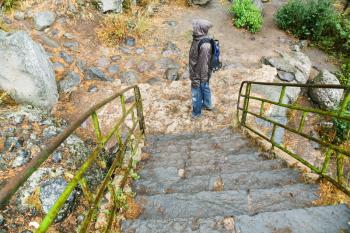 stone steps and tourist in rain in medieval geghard monastery in Armenia