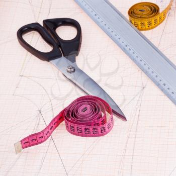 dress pattern at graph paper and tailors shears, ruler, measure tapes