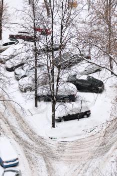 view of cars covered with snow on parking in Moscow, Russia in winter day