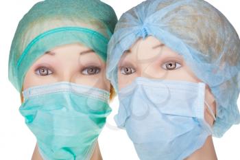 two female mannequin doctor heads wearing textile surgical cap and medical protective mask isolated on white background
