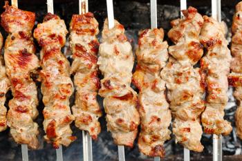 skewers with shish kebabs on brazier close up