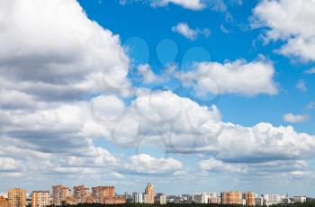 many woolpack clouds over city in summer day