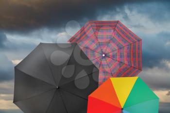 open umbrellas with storm grey clouds background