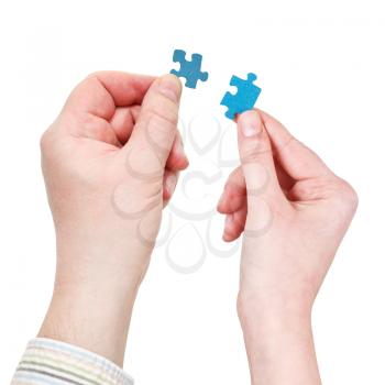 male and female two hands with little puzzle pieces isolated on white background