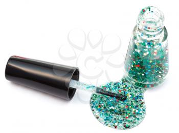 bottle with spilled multicolored glitter nail polish on white background