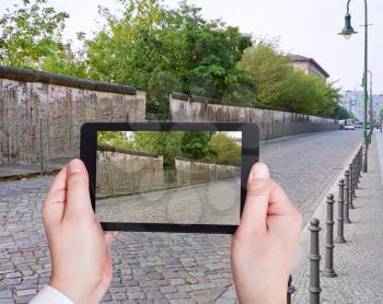 travel concept - tourist taking photo of Berlin Wall on mobile gadget, Germany