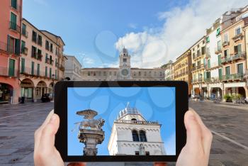 travel concept - tourist taking photo of Piazza dei Signori and Palazzo del Capitanio in Padua on mobile gadget, Italy
