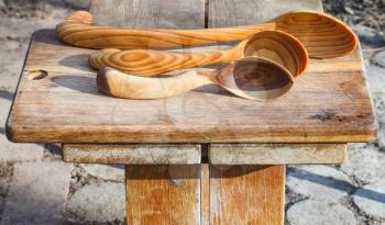 traditional rustic carved wooden spoons on cutting board
