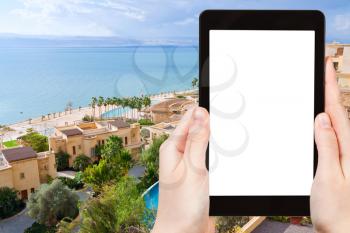 travel concept - tourist photograph resort and Dead Sea , Jordan on tablet pc with cut out screen with blank place for advertising logo