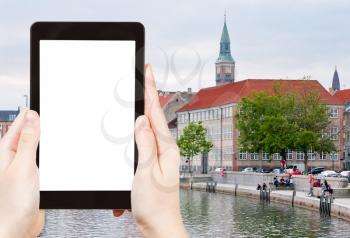 travel concept - tourist photograph Frederiksholms Kanal and Town Hall tower in Copenhagen on tablet pc with cut out screen with blank place for advertising logo