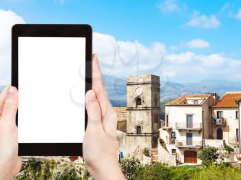 travel concept - tourist photograph Mother Church (Chiesa Madre) in mountain village Savoca in Sicily, Italy on tablet pc with cut out screen with blank place for advertising logo