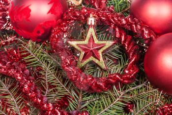 Christmas still life - red star, Christmas balls, tinsel on Xmas tree background
