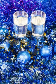 Christmas still life - above view of two glasses of champagne in blue Xmas balls and tinsel