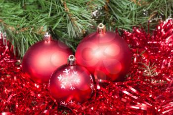 Christmas still life - few red Christmas balls, tinsel on Xmas tree background