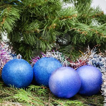 Christmas still life - several blue and violet Christmas balls, tinsel on Xmas tree background