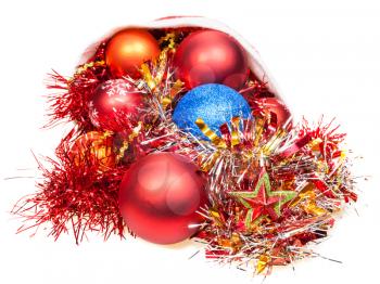 christmas gifts - xmas balls, star and decorations fall out from red santa hat on white background