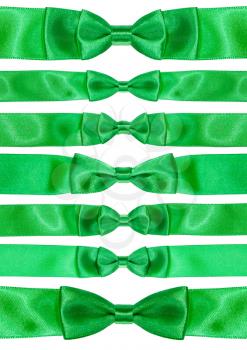 set of symmetric bow knots on green satin ribbons isolated on white background