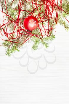 Christmas greeting card - border from one red Xmas ball and tree branch on blank paper background
