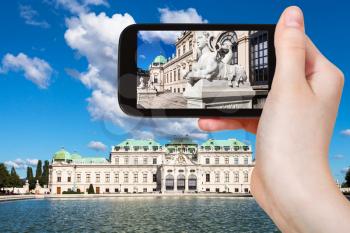 travel concept - tourist snapshot of sphinx statue near Upper Belvedere Palace in Vienna on smartphone