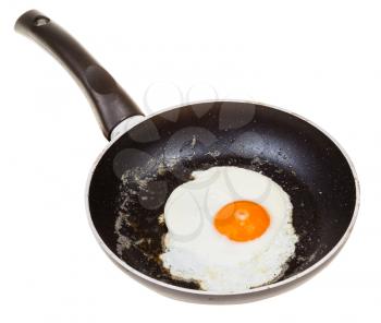 one fried egg in black frypan isolated on white background